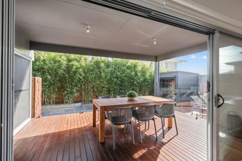 a dining room with a table and chairs on a deck at Mingalar in Cowes