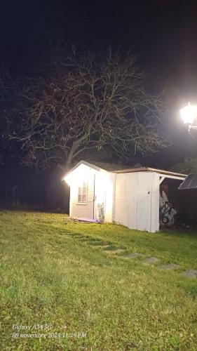 a small white shed with a tree in a field at night at Chez Maurizio in Villemanoche