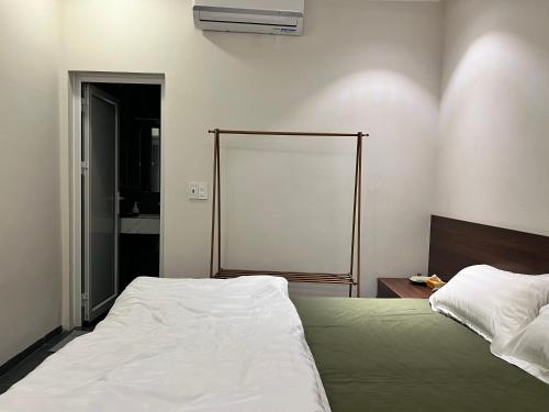 a bedroom with a bed and a blank screen at Lá house Hà Nội in Dong Anh