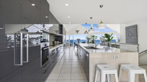 eine Küche mit Theke und Hockern in der Unterkunft Epic View - Pets Stay Free, Beach, 3Bed 3Bath, Luxe in Sapphire Beach