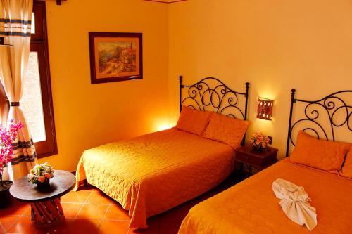 a hotel room with two beds and a window at Hotel Maela in Oaxaca City