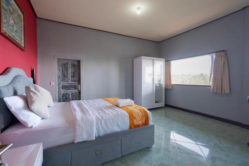 a bedroom with a large bed and a large window at Mountain View House Kintamani in Kintamani