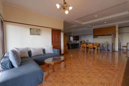 a living room with a blue couch and a table at Mountain View House Kintamani in Kintamani