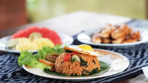 a table with three plates of food on it at Kubu Damai Guest House in Jatiluwih