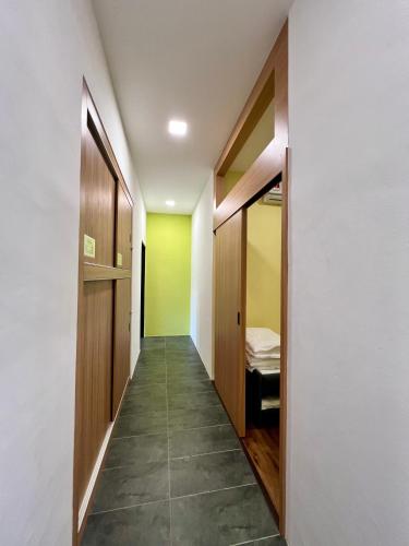 a hallway with green and white walls and wooden doors at Roxy Sematan Beach Townhouse Deluxe 7 ,8 ,9, 10 ,11 ,12 in Sematan