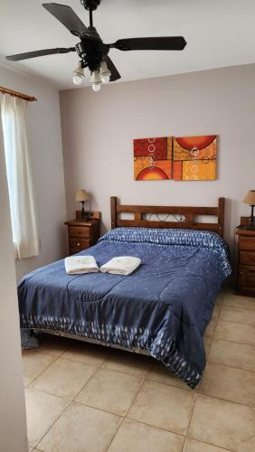 a bedroom with a blue bed with a ceiling fan at Tonatiuh Casas de mar y spa in Mar Azul