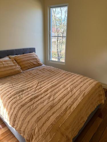 a bedroom with a large bed with a window at Port Kembla Laneway Cottage in Port Kembla