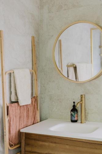 a bathroom with a sink and a mirror at Port Kembla Laneway Cottage in Port Kembla