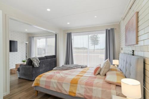 a bedroom with a bed and a large window at Views on Esplanade I Skate Ramp I Sleeps 12! in Seaford