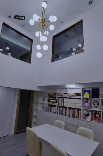 a dining room with a white table and a chandelier at Cloud&Sea Inn in Shenzhen