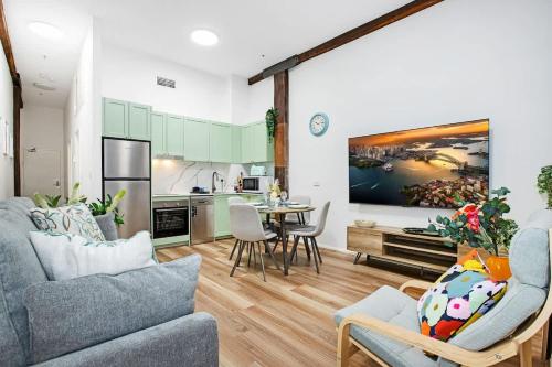 a living room with a couch and a kitchen at Luxe suite in Darling Harbour with pool, sauna & gym - ICC 300m in Sydney