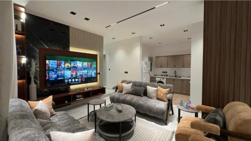 a living room with couches and a flat screen tv at Cozy Stylish Apartment الياسمين شمال الرياض in Riyadh