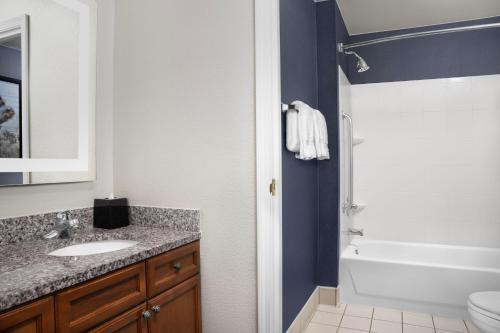a bathroom with a sink and a tub and a toilet at Residence Inn by Marriott San Bernardino in San Bernardino