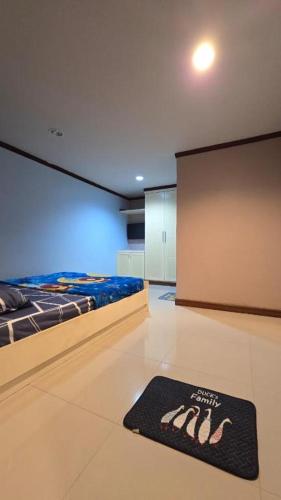 a room with a bed and a black rug on the floor at The Haven Sabi in Bangkok