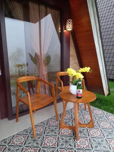 a table and a chair and a table with flowers on a porch at VIP Homestay Lemukih in Singaraja