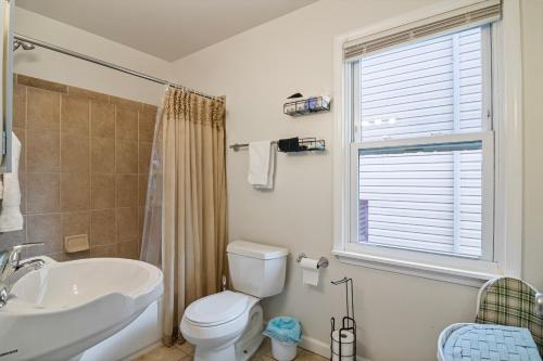 a bathroom with a toilet and a sink and a window at USNA Home In Downtown Annapolis in Annapolis