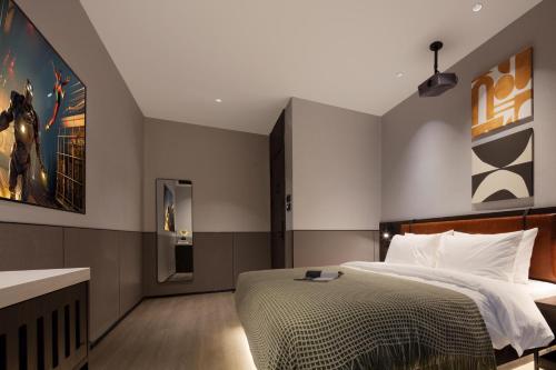a bedroom with a bed and a painting on the wall at Mcsrh Hotel-Xi`an Xiaozhai in Xi'an