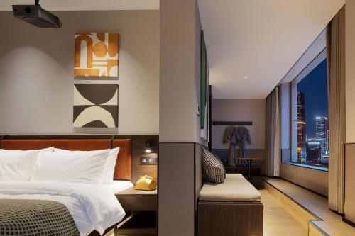 a hotel room with a bed and a view of a city at Mcsrh Hotel-Xi`an Xiaozhai in Xi'an