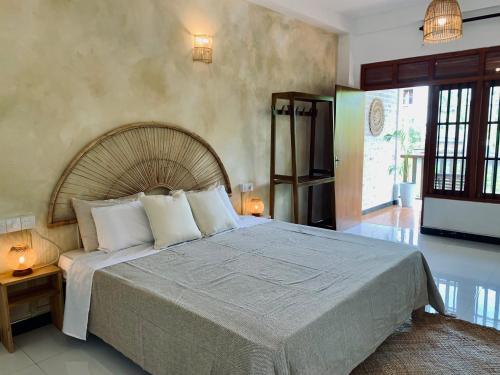 ein Schlafzimmer mit einem großen Bett und weißen Kissen in der Unterkunft Oltremare Mirissa in Mirissa