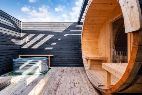 an empty wooden sauna with a bucket on a wooden floor at The Villa Seifumeigetsu in Shiraoi
