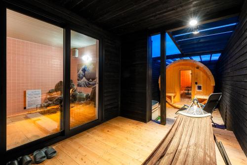a room with large glass windows and a hammock at The Villa Seifumeigetsu in Shiraoi