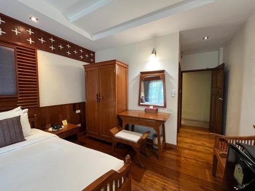 a bedroom with a bed and a desk and a table at Sripat Guesthouse SHA Extra Plus in Chiang Mai