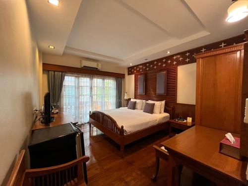 a hotel room with a bed and a desk at Sripat Guesthouse SHA Extra Plus in Chiang Mai