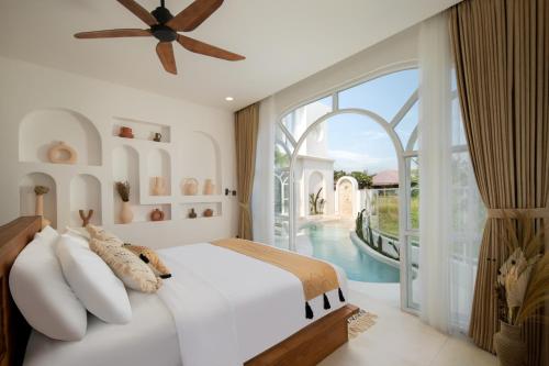 een slaapkamer met een bed met een plafondventilator bij Casa Mana Ubud in Ubud