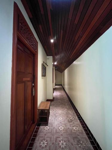 a hallway with a wooden door and a tile floor at Sripat Guesthouse SHA Extra Plus in Chiang Mai