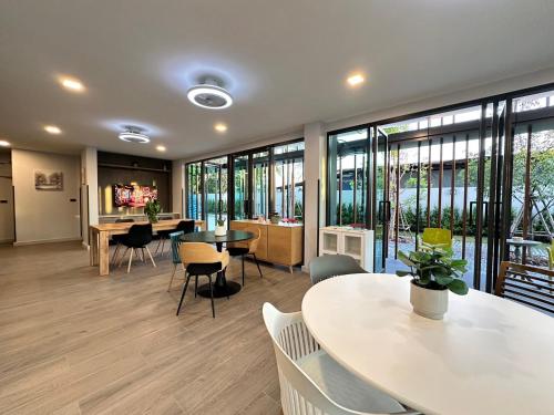 an office with tables and chairs and windows at BB HOUSE Rangsit in Ban Talat Rangsit