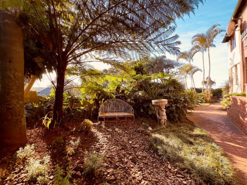 a bench sitting on the ground next to a house at Ridgeview Lodge in Durban
