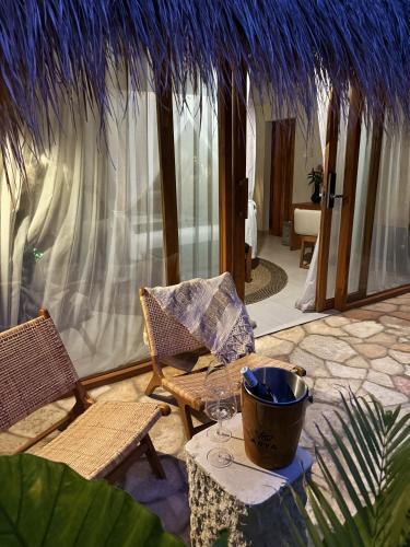 a patio with a table and chairs and a umbrella at ARYA Sumba Resort - Kodi in Tambolaka