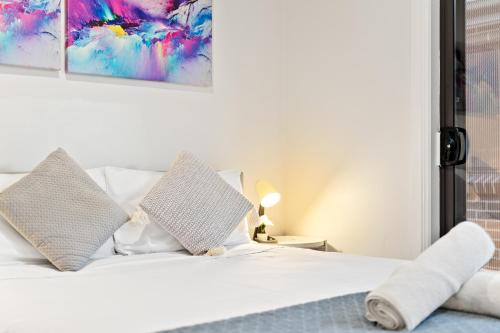 a bedroom with a white bed with two pillows at Boutique Queen Room - Centrally Located at Glenfield - Shared Bathroom in Glenfield