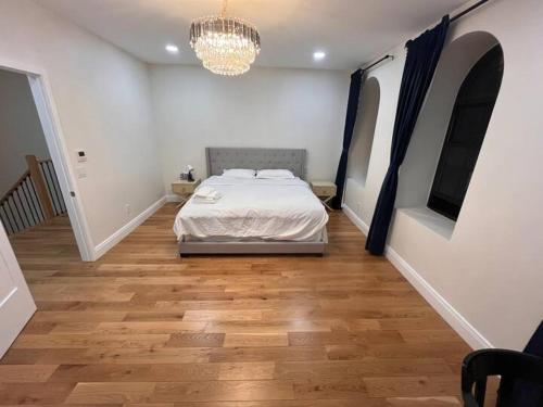 a bedroom with a bed and a chandelier at Little manhattan near Time Square in New York