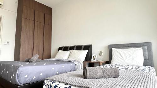 two beds sitting next to each other in a bedroom at LM HomeyC 3BR Family Suite for 4-14 Pax with Nexflix & Coway Water Purifier in Tanjong Tokong