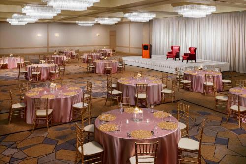 タウソンにあるSheraton Baltimore Northの紫のテーブルクロスが敷かれたテーブルと椅子が置かれた宴会場