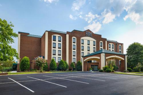 a building with a parking lot in front of it at Four Points by Sheraton Greensboro Airport in Greensboro