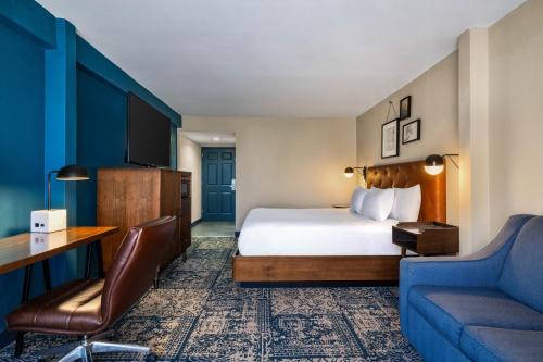 Four Points by Sheraton Greensboro Airport في جرينسبورو: غرفة فندق بها سرير وأريكة