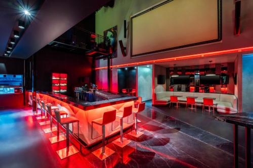 a bar in a restaurant with red lighting at Marriott Hotel Downtown Abu Dhabi in Abu Dhabi