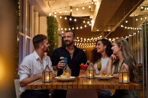a group of people sitting around a table in a restaurant at Marriott Hotel Downtown Abu Dhabi in Abu Dhabi