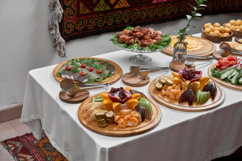 a table with many plates of food on it at Kainar Hotel in Shymkent
