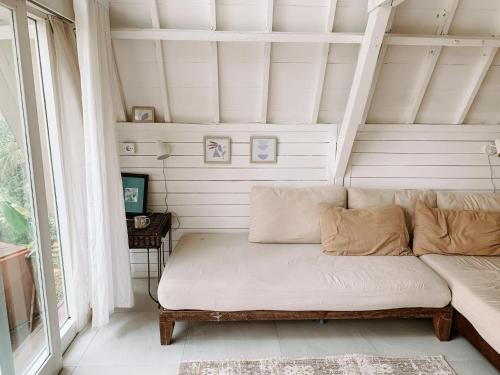 a white couch in a room with a window at The Lookout Cabin in Pupuan Tabanan Bali in Tabanan