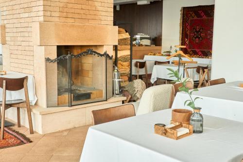 a fireplace in a restaurant with tables and chairs at Kainar Hotel in Shymkent
