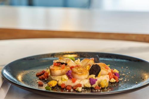 a plate of food with shrimp and vegetables on a table at Sheraton Paris Charles de Gaulle Airport Hotel in Roissy-en-France
