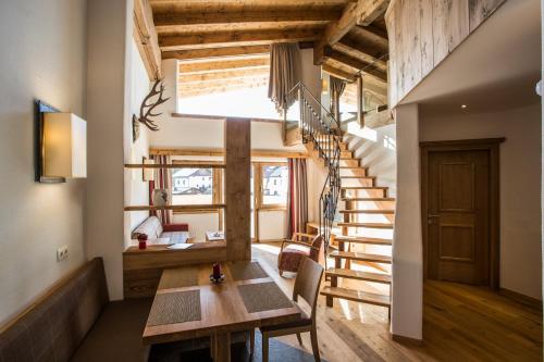 a room with a wooden table and a staircase at Alte Schmiede Hiltpolt in Seefeld in Tirol
