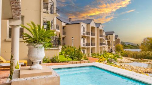 une villa avec piscine devant un immeuble dans l'établissement W-Collection Franschhoek L'Ermitage Villas, à Franschhoek