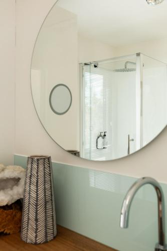 a bathroom with a mirror and a sink at Bracken Retreat - Hobart in Brighton