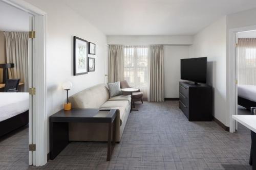 a hotel room with a couch and a tv at Residence Inn by Marriott Corona Riverside in Corona