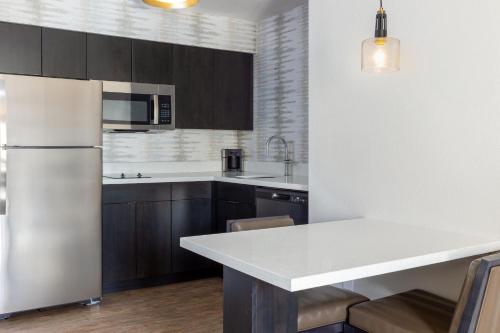 a kitchen with a white refrigerator and wooden cabinets at Residence Inn by Marriott Corona Riverside in Corona
