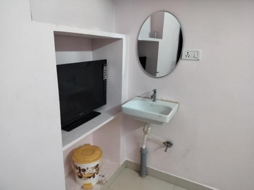 a bathroom with a sink and a mirror at AMC Homestay in Tiruvannāmalai